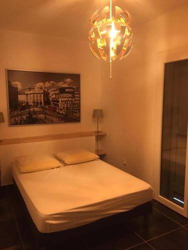 une chambre avec un lit et un lustre dans l'établissement Villa Olivea, à Rayol-Canadel-sur-Mer