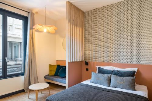 een slaapkamer met een bed en een raam bij HONORÊ - SUITE ARBRE SEC in Lyon