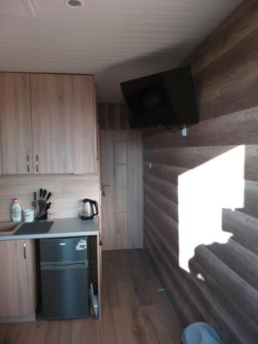 a small kitchen with a sink and a tv on the wall at 2 osobowe kawalerki w domkach FreezerHause Kozery- NoclegiGrodziskPL 792-535-535 in Grodzisk Mazowiecki