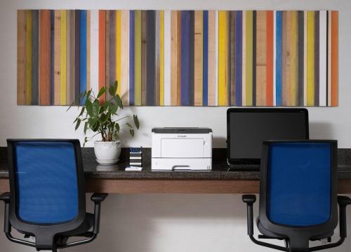 a desk with two chairs and a laptop and a printer at Holiday Inn Express Hotel & Suites Belmont by IHG in Belmont