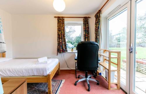 een slaapkamer met een bed, een bureau en een stoel bij Pass the Keys Cosy & Bright Studio with Garden View Free Parking in Cambridge