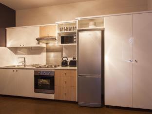 a kitchen with a stainless steel refrigerator and cabinets at Akanani Apartments in Pretoria