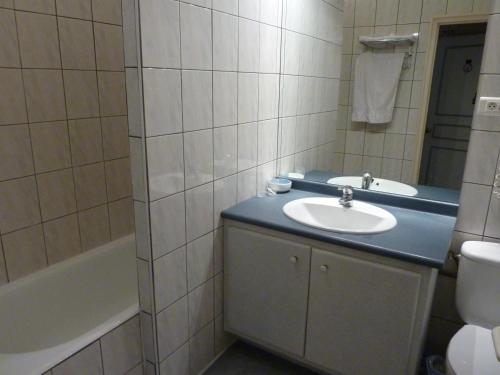 ル・ビュグにあるHotel de Parisのバスルーム(洗面台、トイレ、バスタブ付)