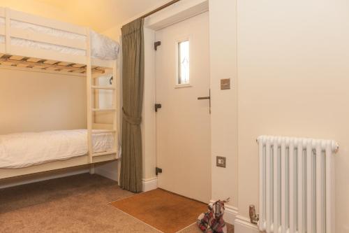 a bedroom with two bunk beds and a window at Thatched Eaves in Ibsley