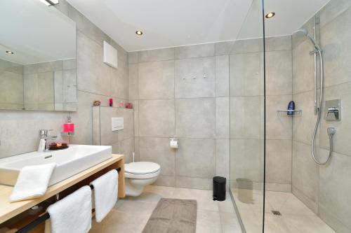 a bathroom with a shower and a toilet and a sink at Ferienhof Sonne in Hittisau