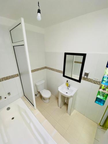 a bathroom with a tub and a toilet and a sink at Zurisadai in Puerto Ayora
