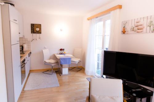 a living room with a table and a kitchen at Wohnung am See in Steinbach am Attersee