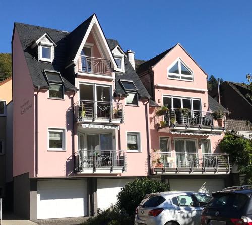 a pink house with cars parked in front of it at Haus Ostermann in Cochem