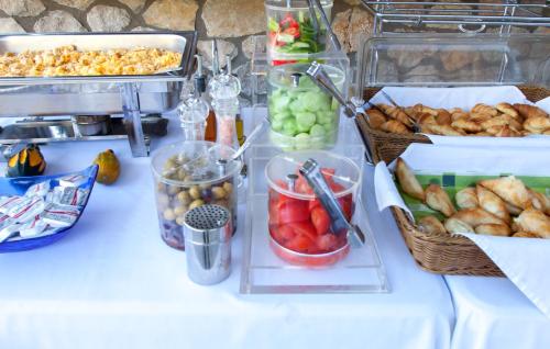 a table with baskets of fruit and other foods on it at Thealos Village aparthotel Lefkada in Lygia