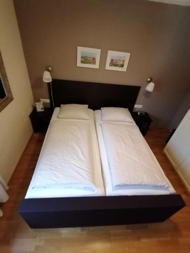 a bed with two white pillows in a room at Komfort Appartements serviced by Auhof in Kaprun
