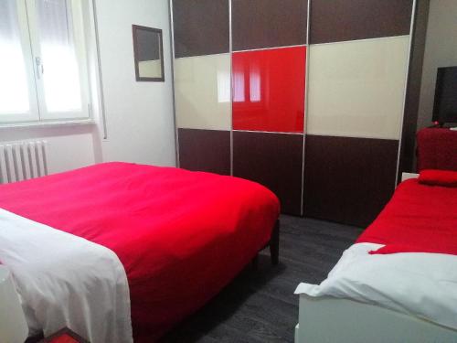 1 Schlafzimmer mit 2 Betten und einer roten Decke in der Unterkunft APT. Re Nasone in Caserta