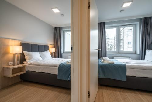 1 dormitorio con 2 camas y ventana en Q19 Apartments Old Town, en Wroclaw
