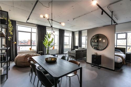 een woonkamer met een tafel en een slaapkamer bij Hilversum City Apartments in Hilversum