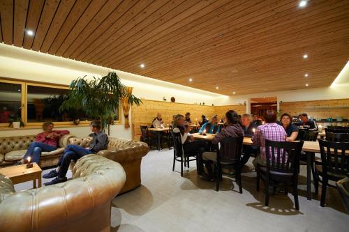 eine Gruppe von Personen, die in einem Restaurant an Tischen sitzen in der Unterkunft Reitstall und Saloon San Jon in Scuol