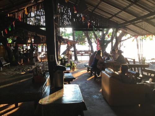 een groep mensen die aan tafel zitten in een restaurant bij Dawn of Happiness in Ao Nam Mao