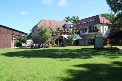 a group of people sitting outside of a building at Schloms Hof in Waffensen