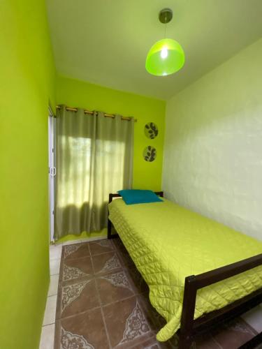 a green bedroom with a bed and a window at Zurisadai in Puerto Ayora