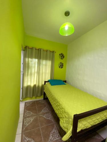 a green bedroom with a bed and a window at Zurisadai in Puerto Ayora