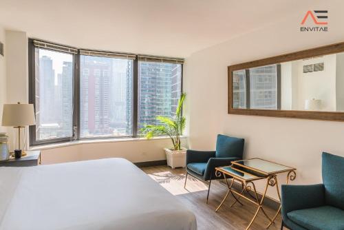 a hotel room with a bed and two chairs at ENVITAE 2BR Vibrant High-Rise Penthouse in Chicago