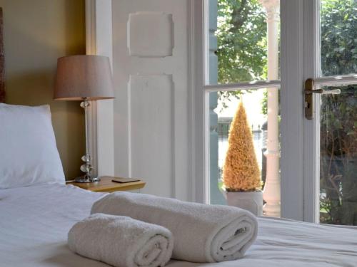 a bedroom with a bed and a window with a christmas tree at Llys yr Wylan in Aberystwyth