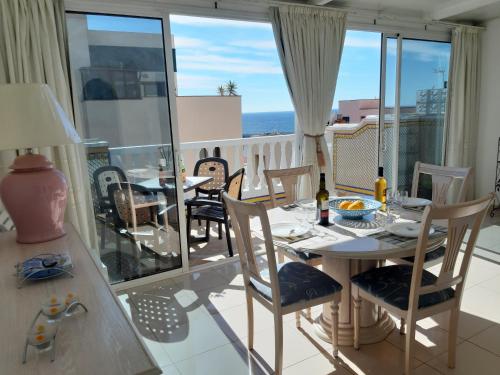 una sala da pranzo con tavolo e sedie sul balcone di LOS CRISTIANOS LUXURY SEA VIEW ad Arona