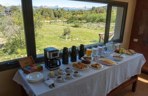 a table with food on it in front of a window at Hostería La Chira in San Martín de los Andes