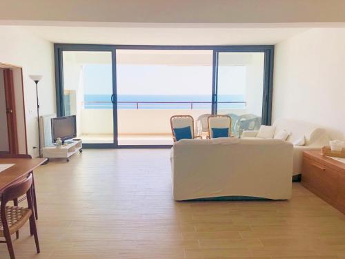 a living room with a couch and chairs and a television at Appartamento Capo Mimosa in Cervo