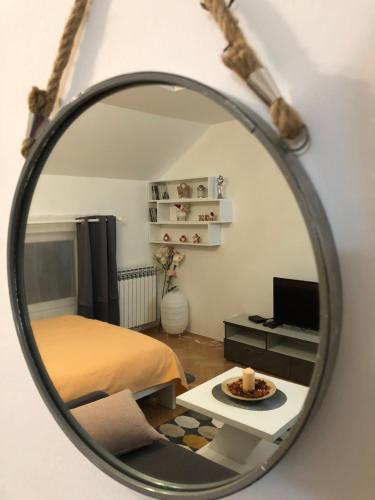 espejo que refleja un dormitorio con cama y mesa en Apartman Ana en Dušanovac (historical)