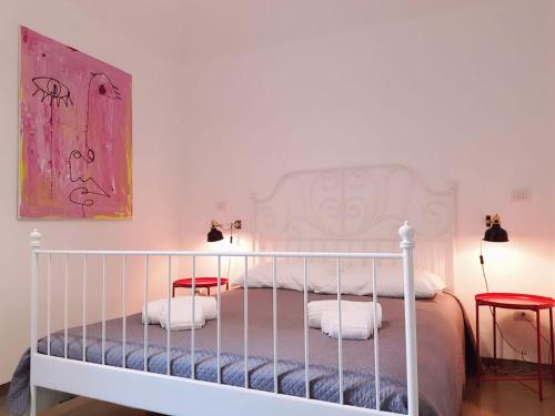una camera con un letto bianco e due sedie rosse di Casa Romeo ad Acireale