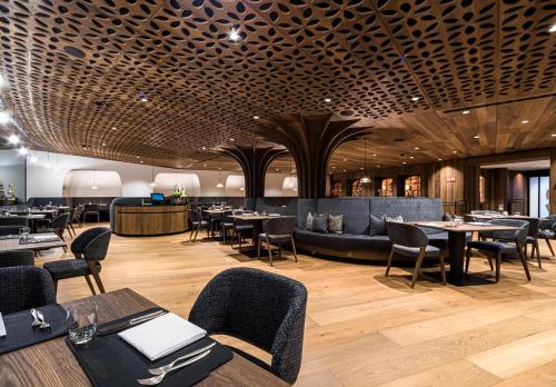 a restaurant with tables and chairs and a bar at Granbaita Dolomites in Selva di Val Gardena