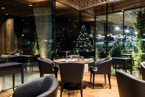a restaurant with a christmas tree and tables and chairs at Granbaita Dolomites in Selva di Val Gardena
