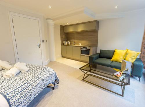 una camera con letto e divano e una cucina di Riverside Studio Apartments Close To City Centre a York