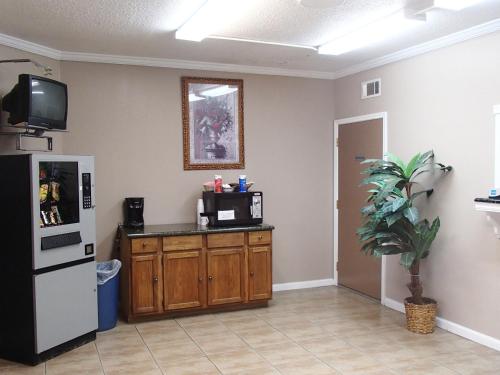 a living room with a refrigerator and a microwave at Sunrise Inn Lake Charles in Lake Charles