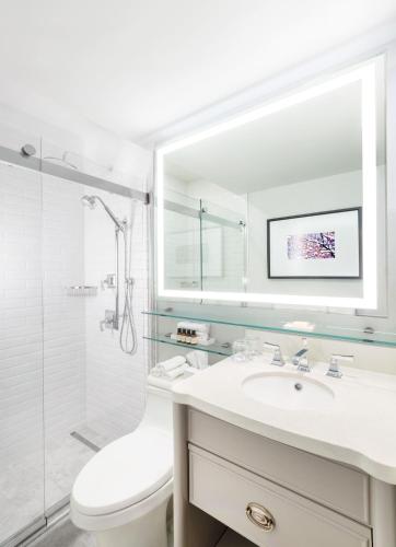 a white bathroom with a sink and a shower at Fairmont Le Chateau Montebello in Montebello