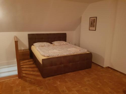 a bed in a room with a wooden floor at U Královny Dagmar in Karlštejn