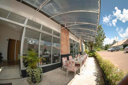 a building with a table and chairs outside of it at Llanogrande Airport by Bernalo Hotels in Rionegro