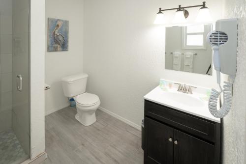 een witte badkamer met een toilet en een wastafel bij Sun Outdoors Key Largo in Key Largo