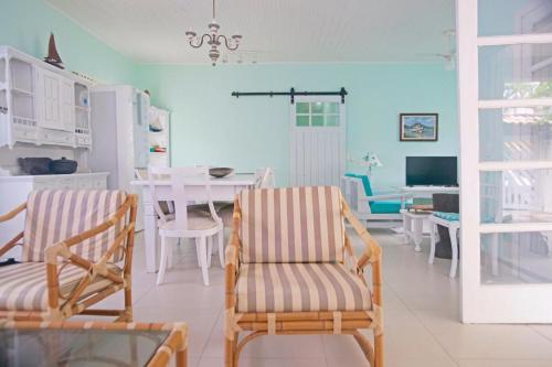 ein Wohnzimmer mit zwei Stühlen und einem Tisch in der Unterkunft Beach House in Ubatuba