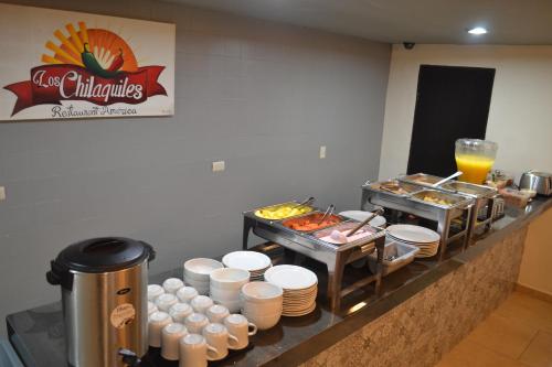 a buffet line with food and drinks in a restaurant at Hotel America Centro in Los Mochis