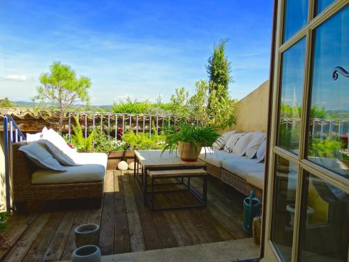 a patio with two couches and a table on a deck at Un Patio en Luberon in Ansouis