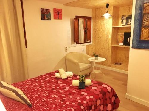 a bedroom with a bed with a red blanket and a chair at La Fuente de Arnedillo in Arnedillo