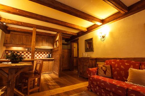 a living room with a couch and a table at Au Coeur Des Neiges Resort SPA & FREE E-BIKE in Courmayeur
