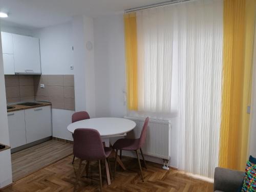 una cucina con un tavolo e sedie in una stanza di Apartman Tamara a Pale