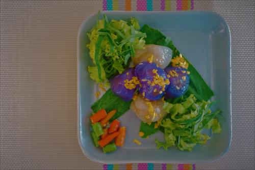 Boutique Family Room Phitsanulok في بيتسانولوك: طبق من الطعام مع الخضروات على الطاولة