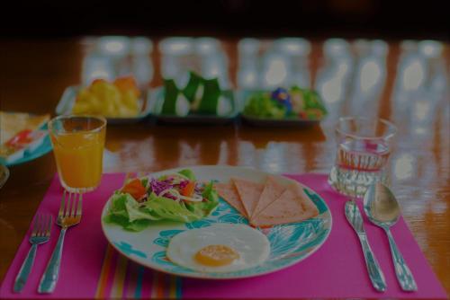 a plate of food with a egg and salad on a table at Boutique Family Room Phitsanulok in Phitsanulok