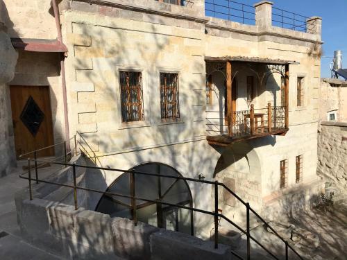 an old building with a staircase and a balcony at Naraca Cave House in Goreme