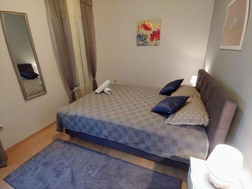 a small bedroom with a bed and a mirror at Apartments Tulipan - with free private parking in Mostar