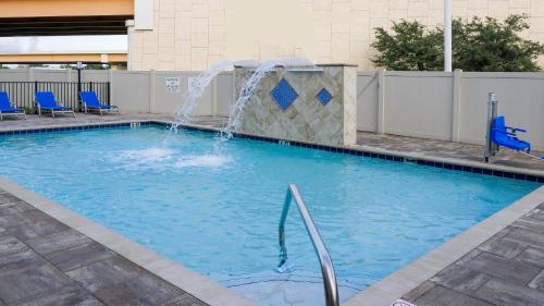 Holiday Inn Express & Suites - Tampa East - Ybor City, an IHG Hotel في تامبا: مسبح مع نافورة ماء