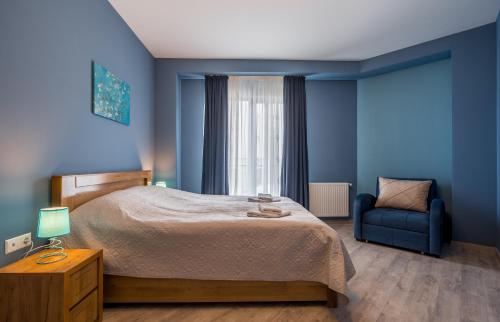 a bedroom with blue walls and a bed and a blue chair at New Gudauri, Loft 1, #114, Cosy Apartment -Gondola lift in Gudauri