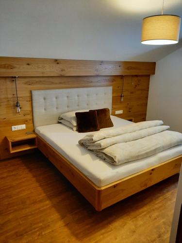 a bedroom with a large bed with a wooden headboard at Ferienwohnung Schachner in Heiligenblut